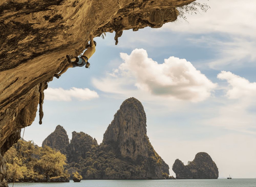 Rock climbing in Krabi, Thailand offers an exhilarating challenge on towering limestone cliffs with breathtaking views of turquoise waters and sandy beaches (Source: Internet)